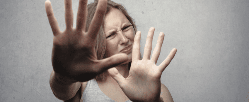 Confident woman raising her arms and hands in a 'stop' gesture, firmly saying 'no' with determination
